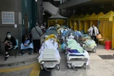 Des patients alités à l'extérieur du centre médical de Caritas à Hong Kong, le 15 février 2022