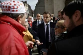 Le président Emmanuel Macron (c) rencontre des habitants sur un marché de Dole, le 27 avril 2023 dans le Jura