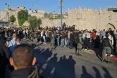 Les forces de sécurité israéliennes tiennent des Palestiniens à l'écart devant la porte de Damas, dans la vieille ville de Jérusalem, rassemblés pour observer une manifestaton de nationalistes israéliens se dirigeant vers la place Tzahal, le 20 avril 2022.
