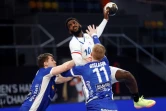 L'ailier droit français, Dika Nem tire malgré les défeneurs islandais, lors du Mondial de handball, le 22 janvier 2021 dans la Ville du 6 Octobre, un faubourg proche du Caire