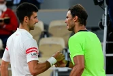 Le Serbe Novak Djokovic (gauche) et l'Espagnol Rafael Nadal se serrent la main après leur match, en demi-finale du tournoi de Roland-Garros, le 11 juin 2021 à Paris 