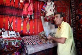 Un vendeur montre des tapis traditionnels dans son échoppe du marché de Hilla, le 12 octobre 2017 en Irak