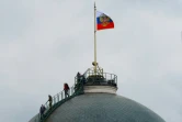 Des personnels du Kremlin inspectent la coupole du Palais du Sénat, touchée dans la nuit par une attaque de drone explosif attribuée à l'Ukraine, le 3 mai 2023 à Moscou
