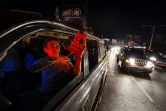 Des personnes utilisent leur téléphone portable sur l'autoroute Francisco Fajardo où ils ont du réseau le 9 mars 2019, pendant la panne d'électricité qui frappe le Venezuela