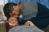 Un homme réconforte son fils blessé dans des bombardements du régime syrien et hospitalisé à Arbine, le 20 février 2018
