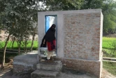 Photo du 15 novembre 2018 montrant une femme pakistanaise sortant des toilettes à Basti Ameerwala (centre)