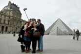 Des touristes devant le Louvre le 7 mars 2015 à Paris