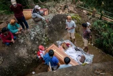 Des membres d'une famille toraja exhument le corps d'un proche pendant le rituel traditionnel "Manene" à Pangala, dans le sud de l'île des Célèbes, le 27 août 2024s en Indonésie