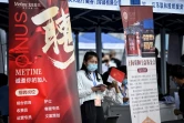 Une femme tient un stand lors d'un salon de l'emploi, le 26 août 2022 à Pékin 
