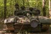 Un militaire ukrainien porte un obus d'un char T-72 de fabrication soviétique, dans la région de Soumy, près de la frontière avec la Russie, le 12 août 2024