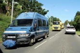 Un véhicule des forces de l'ordre escorte des camions de l'équipement pour dégager un barrage, le 24 mai 2024 à Nouméa