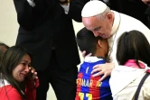 Le pape François étreint un jeune garçon lors d'une audience de personnes atteintes par la maladie de Huntington, au Vatican, le 18 mai 2017
