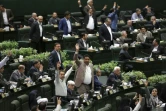 Des députés iraniens se lèvent alors que le président iranien Hassan Rohani s'exprime devant le Parlement à Téhéran, le 28 août 2018