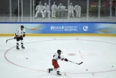 Les joueurs de Beijing Arcfox s'entraînent sous le regard attentif des soigneurs, dans la patinoire des Jeux, le 11 novembre 2021 à Pékin