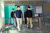 Des voyageurs quittent l'hôtel Regal Airport à l'aéroport Lap Kok de Hong Kong où un cas du nouveau variant du Covid-19 a été détecté sur un voyageur en provenance d'Afrique du Sud, contaminant une autre personne pendant sa quarantaine, le 26 novembre 2021