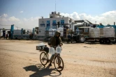 Un jeune Palestinien transporte des bidons d'eau après la fermeture de l'usine de dessalement de l'eau à Deir el-Balah, dans le centre de la bande de Gaza, le 10 mars 2025