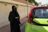 La chauffeure de taxi saoudienne Fahda Fahd pose pour une photo près de sa voiture dans la capitale Riyad, le 8 février 2022. Comme d&rsquo;autres femmes saoudiennes, Fahda Fahd ne pouvait pas conduire légalement avant 2018, mais sa Kia vert lime est maintenant une voie vers de l&rsquo;argent supplémentaire alors que le coût de la vie monte en flèche dans le royaume conservateur.