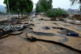 La population constate les dégâts après les intempéries à Mihe, dans la province du Henan (centre de la Chine), le 22 juillet 2022