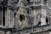 Des ouvriers installent des bâches de protection sur le toit de Notre-Dame de Paris, le 23 avril 2019