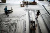 Des peintres travaillent sur des grandes toiles en trompe-l'oeil du décor en noir et blanc du ballet "Le Rouge et le Noir" du chorégraphe français Pierre Lacotte, le 30 avril 2021 dans les ateliers de l'Opéra Bastille, à Paris