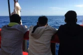 Des migrants secourus en mer regardent les côtes siciliennes depuis le navire humanitaire Ocean Viking, le 5 juillet 2020 en Méditerranée  
