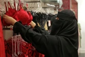 Une vendeuse arrange sur des portants des soutiens-gorge de couleur rouge dans une boutique à Ryad, le 9 février 2022 en Arabie saoudite