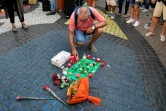 Des passants déposent des fleurs et des bougies sur la Rambla de Barcelone le 18 août 2017 en hommage aux victimes