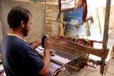 Un homme tisse un tapis traditionnel dans une échoppe du marché de Hilla, le 12 octobre 2017 en Irak