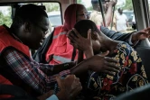 Un membre de la Croix-Rouge réconforte un fidèle de l'Eglise Internationale de Bonne Nouvelle, près de la ville cotière de Malindi, le 25 avril 2023 au Kenya 