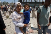 Des Palestiniens fuient une école où ils s'étaient réfugiés, après une frappe israélienne, à Deir el-Balah, dans le centre de la bande de Gaza, le 27 juillet 2024
