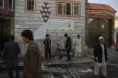 Des habitants inspectent le site d'un attentat-suicide qui a fait quatre morts devant un centre d'inscription sur les registres électoraux, à Kaboul le 22 avril 2018