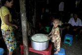 Un enfant devant une marmite de riz distribué par le PAM à Rangoun le 21 mai 2021