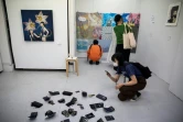 Des visiteurs regardent et photographient  des oeuvres exposées dans la galerie d'art Same où le vol des oeuvres est permis, le 9 juillet 2020 à Tokyo 