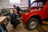 Sergueï Diogrik (g), responsable du Lada History Club, et son assistant Kamil restaurent une Lada Niva des années 1980, 4X4 de légende, dans leur garage à Togliatti, en Russie, le 31 mars 2022