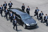 Des gardes du corps accompagnent en courant la voiture transportant le leader nord-coréen Kim Jong-Un après une session matinale de discussions au village de Panmunjom, le 27 avril 2018