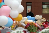 Le président russe Vladimir Poutine dépose des fleurs en hommage aux victimes d'un incendie dans un centre commercial, le 27 mars 2018 à Kemerovo, en Sibérie