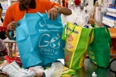 Un employé d'un supermarché emballe les achats de clients dans des sacs en tissu, le 16 juillet 2019 à Bali