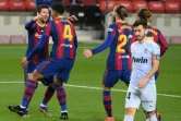 Lionel Messi (g) fêté par ses coéquipiers après avoir marqué son 643e but pour le Barça contre Valence, le 19 décembre 2020 au Camp Nou de Barcelone