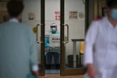 Un membre du personnel médical en combinaison de protection (c) attend de prendre la température des personnes qui arrivent à l'hôpital Princess Margaret, le 4 février 2020 à Hong Kong