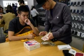 Un homme achète deux iPhone X dans une boutique Apple, le 3 novembre 2017 à Hong Kong