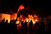 Des manifestants irakiens devant le consulat iranien en flammes dans la ville sainte chiite de Najaf, dans le sud de l'Irak, le 27 novembre 2019