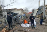 Trois hommes devant des ruines provoquées par un bombardement des forces russes à Jitomir, en Ukraine, le 2 mars 2022