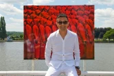 L'artiste chinois Liu Bolin prend la pose devant l'une de ses oeuvres lors d'une exposition à Vichy le 16 juin 2017