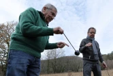 Les sourciers espagnols Enric Colom et Lluis Sarsanedes Bosch cherchent de l'eau avec des pendules et des bâtons dans un champ asséché de Sant Feliu de Pallerols près de Gérone en Catalogne le 15 janvier 2024 
