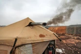 Une fumée noire s'échappe de la tente du réfugié Oum Raed, le 16 décembre 2021 au camp de déplacés de Kfar Arouk, dans le nord-ouest de la Syrie