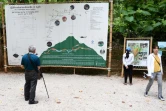 Un visiteur regarde une carte expliquant le sauvetage des adolescents thaïlandais à l'entrée de la grotte de Tham Luang, le 13 juin 2019 à Mae Sai