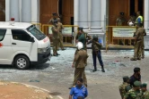 Des personnels de sécurité sri-lankais se tiennent près d'une ambulance devant l'église Saint-Anthony à Colombo après une explosion meurtrière, le 21 avril 2019