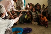 Des habitants ayant fui les violences dans la région du Tigré, en Ethiopie, partagent le seul repas de la journée dans une ancienne classe d'école transformée en abri de fortune, à Mekele, le 19 juin 2021