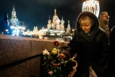 Une femme dépose des fleurs le 27 février 2020 à l'endroit où a été abattu par balles il y a cinq ans l'opposant russe Boris Nemtsov, sur un pont près du Kremlin