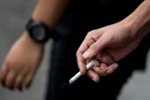 Un homme tient une cigarette dans sa main, le 13 octobre 2016 à Manille. Le tabagisme absorbe environ 6% des dépenses mondiales consacrées à la santé